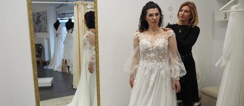 Derya Yilmaz steht in einem Brautkleid vor einem Spiegel.