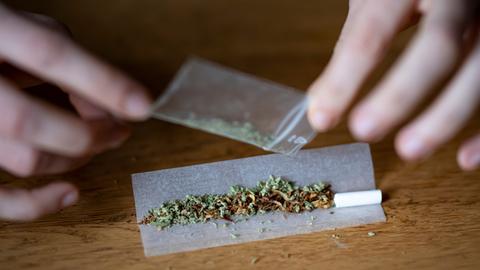 Symbolbild: Ein Mensch dreht einen Joint aus Tabak und Cannabis.