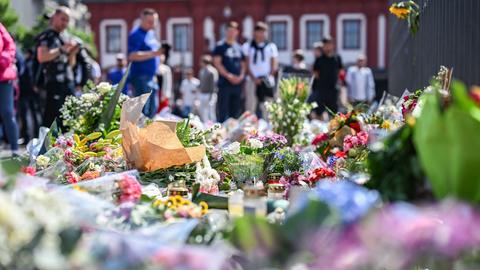 Nach dem Tod eines Polizisten liegen am Marktplatz in Mannheim in der unmittelbaren Nähe des Tatorts Blumen und Kerzen.