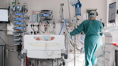 Ein Pfleger steht an einem Bett auf einer Intensivstation in Braunschweig. (dpa)