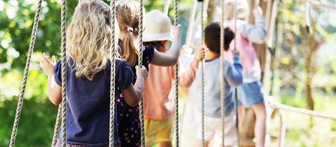 Kinder laufen in einer Kita über eine Hängebrücke. (dpa)