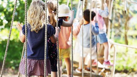 Kinder laufen in einer Kita über eine Hängebrücke. (dpa)