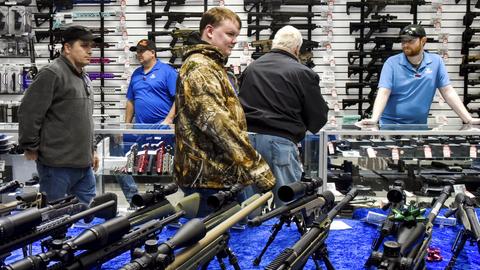 In einem Waffengeschäft schauen sich Kunden Waffen an. (dpa)
