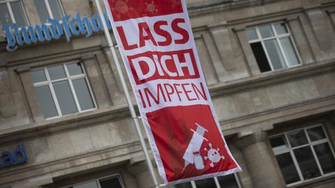 "Lass Dich impfen" steht auf einer Fahne während einer Corona-Impfaktion der Stadt Köln vor dem Hauptbahnhof (dpa)