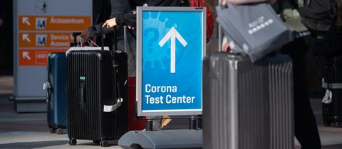 Reisende mit Koffern stehen vor einem Corona-Testzentrum auf dem Flughafen in München an. (dpa)