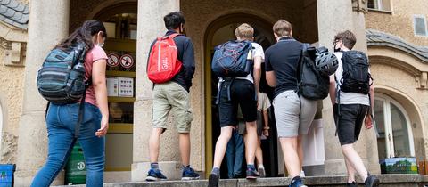 Schüler betreten den Eingang zum Rheingau Gymnasium. (Archivbild: August 2020) (dpa)