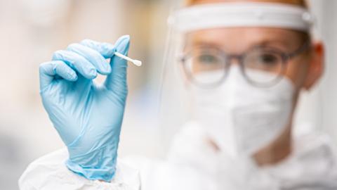 Eine Mitarbeiterin des Testzentrums am Platz der Weltausstellung hält einen Teststab für einen Schnelltest auf das Coronavirus in ihren Händen (gestellte Szene, Archivbild)). (dpa)