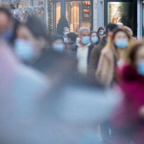 Nordrhein-Westfalen, Düsseldorf: Menschen mit Mund-Nasen-Schutz gehen durch eine Fußgängerzone. (dpa)