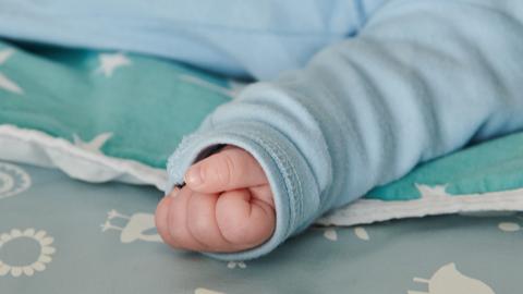 Ein wenige Wochen altes Baby hat die Hand zur Faust geballt. (dpa)