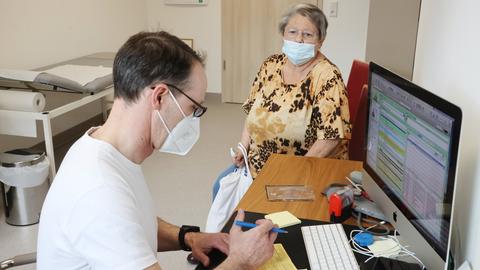 Ein Hausarzt spricht mit einer Patientin in seiner Praxis in Thüringen. (dpa)