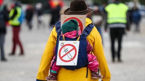 Eine Teilnehmerin einer Protestkundgebung der Initiative "Querdenker" trägt auf dem Cannstatter Wasen ein Schild gegen Impfungen auf ihrem Rücken. (dpa)