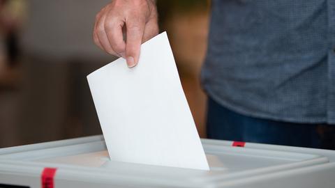 Ein Wähler wirft seinen Stimmzettel in eine Wahlurne. (picture alliance/dpa/dpa-Zentral)