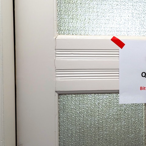 Ein Zettel mit der Aufschrift "Häusliche Quarantäne Bitte Abstand halten!!!" hängt an einer Tür (picture alliance / Jochen Tack)