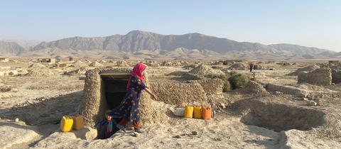 Eine Frau kommt im Flüchtlingslager Masar aus einem Eingang, Afghanistan. ()