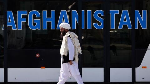 Ein Mitglied der Taliban geht vor einem Afghanistan-Schriftzug am Flughafen Kabul vorbei (Archivbild). (AFP)