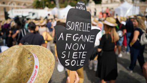 "Afghanische Schwestern, ihr seid nicht allein" steht auf einem Plakat, das eine Person auf einer Kundgebung für Afghanistan in Rom hochhält (Bild vom 25.09.2021). (AP)