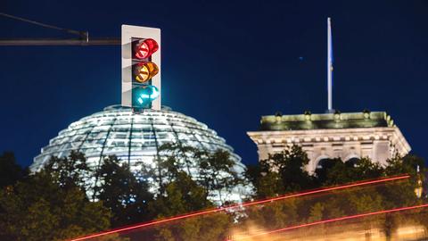 Eine Ampel vor dem Reichstagsgebäude leuchtet in allen drei Phasen. (dpa)