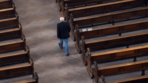  Ein Mann geht im Dom in Fulda (Hessen) an leeren Kirchenbänken vorbei. (dpa)
