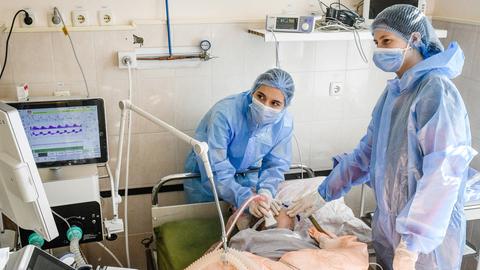 Mitarbeiter des Gesundheitswesens kümmern sich um einen Patienten auf der Corona-Intensivstation eines Krankenhauses  in der ukrainischen Stadt Saporischschja  (dpa)