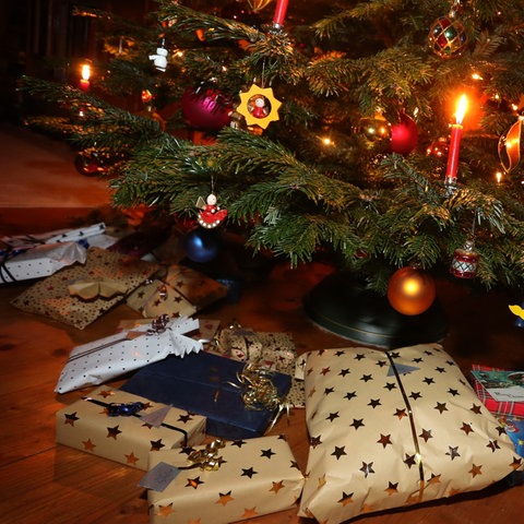 Pakete liegen unter einem geschmückten Weihnachtsbaum (dpa)