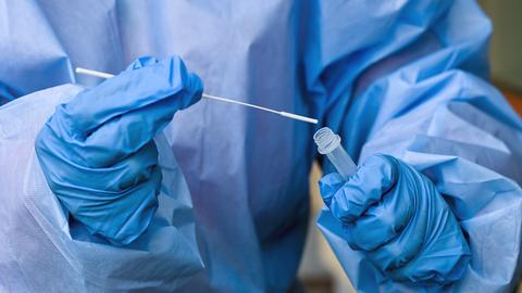  Eine Krankenschwester eines mobilen Test-Teams steckt während einer Corona-Testung ein Teststäbchen in die Flüssigkeit eines Schnelltests. (dpa)