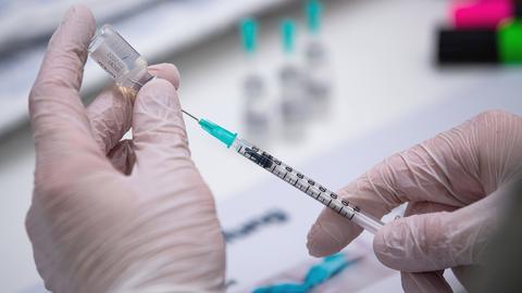 Ein Mitarbeiter einer Corona-Impfaktion bereitet BioNTech-Dosen vor. (dpa)
