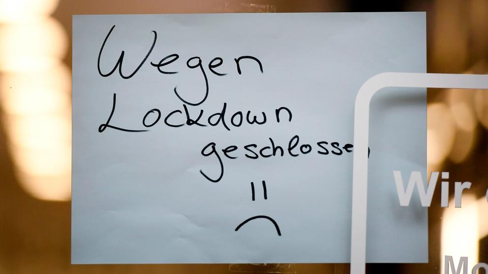 Ein Schild mit der Aufschrift "Wegen Lockdown geschlossen" hängt in einem Geschäft in Köln (AFP)