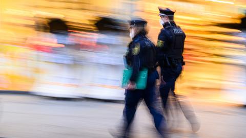 Polizisten laufen auf der Einkaufsmeile Prager Straße vor Geschäften entlang. Die Polizeidirektion Dresden kontrolliert die Einhaltung der neuen Corona-Regeln täglich mit 50 Beamtinnen und Beamten. (dpa)