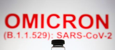 Ein Fläschchen steht vor dem Text "Omicron (B.1.1.529): SARS-CoV-2" (picture alliance / ZUMAPRESS.com)
