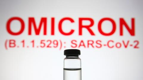 Ein Fläschchen steht vor dem Text "Omicron (B.1.1.529): SARS-CoV-2" (picture alliance / ZUMAPRESS.com)