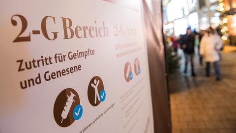 An einem Weihnachtsmarkt hängt ein Schild mit der Aufschrift «2-G Bereich, Zutritt für Geimpfte und Genesene. (dpa)