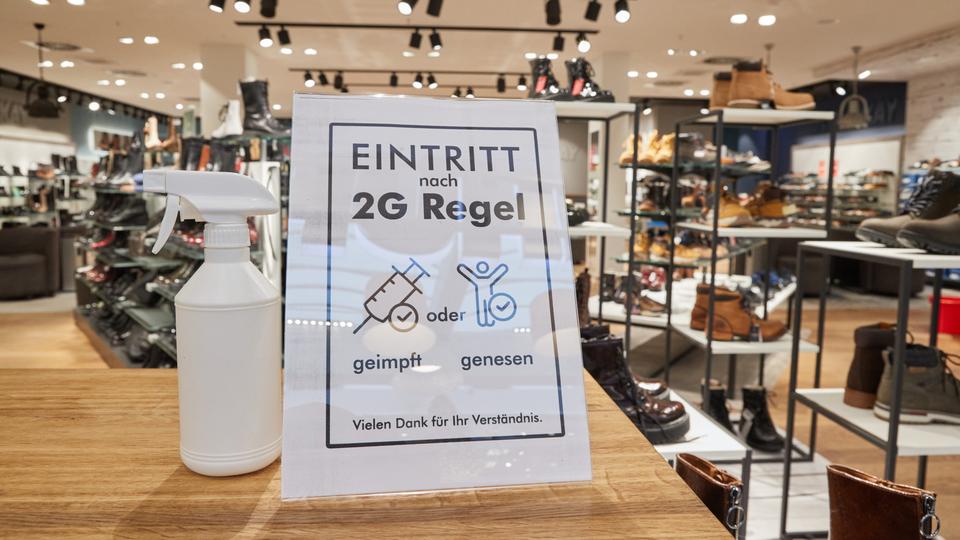 Ein Hinweisschild mit der Aufschrift "Eintritt nach 2G Regel geimpft oder genesen" steht am Eingang eines schuhgeschäfts in Norderstedt (dpa)