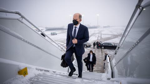 Scholz beim Betreten der Regierungsmaschine am verschneiten Berliner Flughafen (dpa)