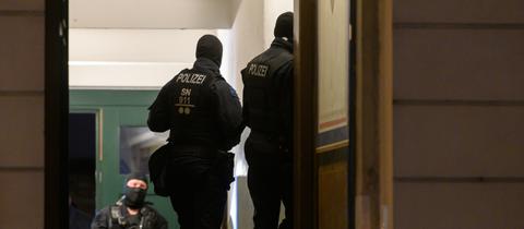 Polizisten stehen bei einer Razzia in einem Haus im Dresdner Stadtteil Pieschen.  (dpa)