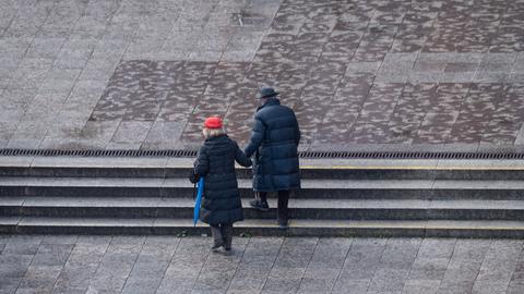 Ein älteres Paar geht über die Hauptwache in Frankfurt am Main.  (dpa)
