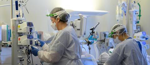 Intensivpflegerinnen sind in Schutzkleidung auf einer Covid-19-Intensivstation. (picture alliance/dpa/dpa-Zentral)