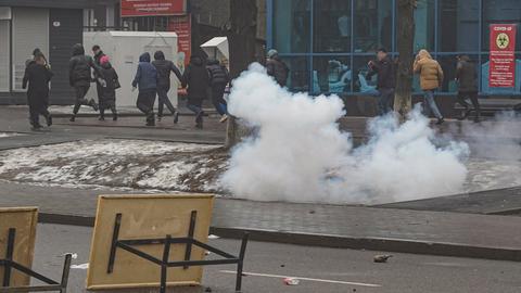 Bei Protesten in Kasachstan laufen Menschen eine Straße entlang. (EPA)