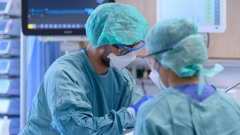 Intensivpfleger sind in der Corona-Intensivstation des Universitätsklinikums Dresden mit der Versorgung von Patienten beschäftigt. (dpa)