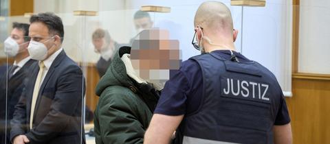 Der Angeklagte Anwar R. wird von einem Justizbeamten zur Urteilsverkündung in den Gerichtssaal des Oberlandesgerichts Koblenz geführt. (REUTERS)