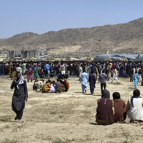 Hunderte Menschen warten vor einer US-Militärmaschine am Flughafen in Kabul, Afghanistan. (AP)