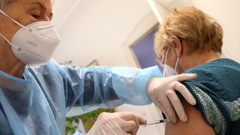 Eine Frau lässt sich in der Praxis ihrer Hausärztin die dritte Impfung mit dem Comirnaty-Impfstoff des Herstellers BioNTech/Pfizer injizieren. (dpa)
