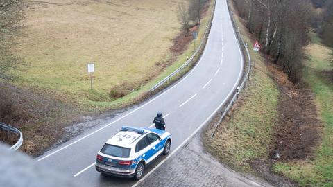 Ein Polizeibeamter steht an einer Absperrung an der Kreisstraße 22. (dpa)