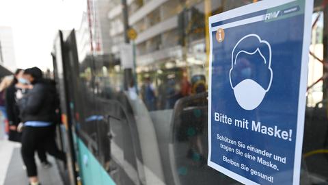 Ein Plakat mit der Aufschrift "Bitte mit Maske!" ist in einem Bus des Rhein-Main-Verkehrsverbunds in Frankfurt angebracht. (dpa)
