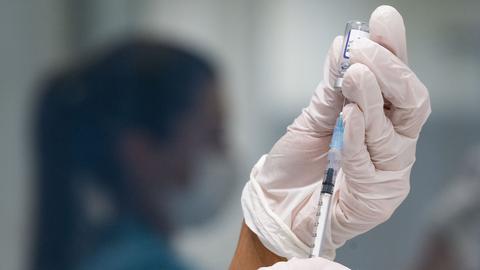 Eine Werksärztliche Assistentin zieht in einem betrieblichen Impfzentrum eine Dosis des Impfstoffes von BioNTech/Pfizer auf. (dpa)