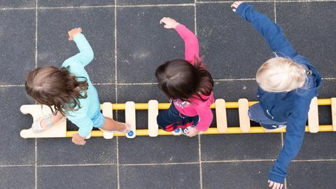 Kinder balancieren auf dem Spielplatz einer Kindertagesstätte im sächsischen Dresden auf einem Brett. (dpa)