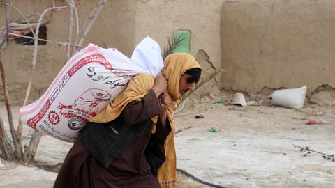 Ein Mann in Afghanistan trägt eine Lebensmittelspende  (EPA)