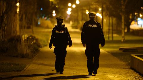 Polizisten laufen in der Nacht im Stadtteil Gorbitz Streife und kontrollieren die Einhaltung der Ausgangssperre. (dpa)