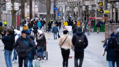 Passanten laufen durch die Fußgängerzone. (dpa)