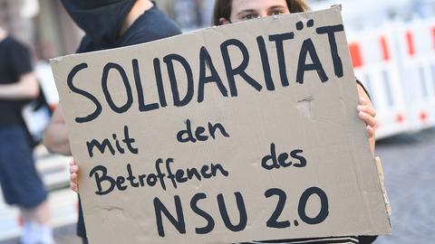 Ein Demonstrantin hält während einer Kundgebung in der Wiesbadener Innenstadt ein Plakat mit der Aufschrift "Solidarität mit den Betroffenen des NSU 2.0".  (dpa)