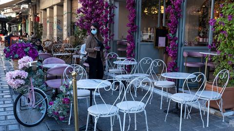 Eine Frau steht vor einem Café in Athen. (AP)